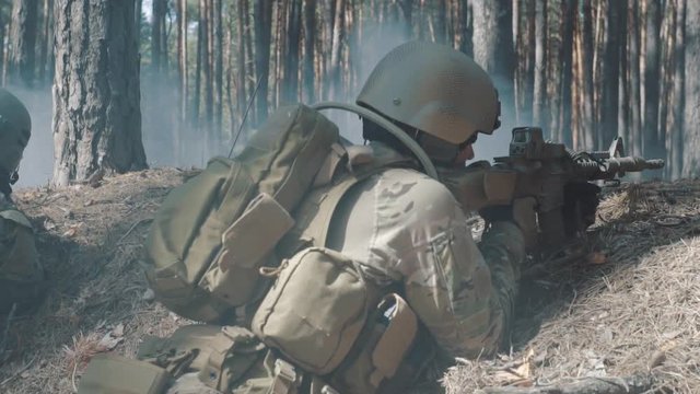 Soldiers are fighting in a trench in a smoky forest