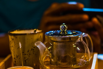 The cup of the tea and teapot in the wooden plate