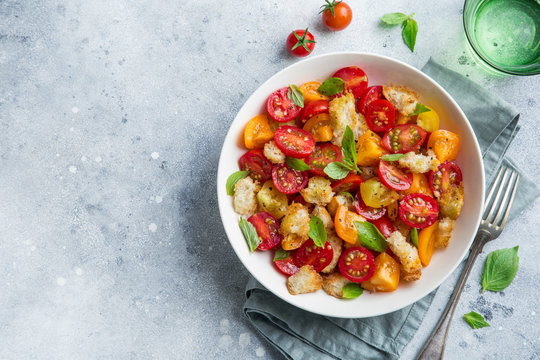 panzanella, traditional italian tomato and bread salad in white bowl