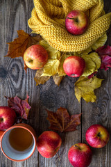 red apples autumn leaves on wooden background