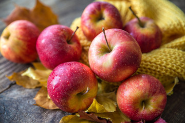 red apples autumn leaves on wooden background