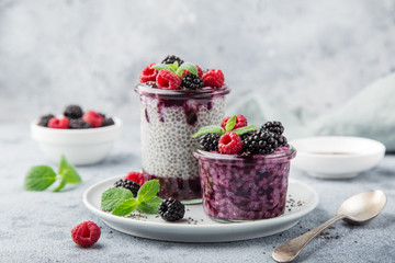 chia seeds pudding with berry sauce and fresh raspberry and blackberry in glass