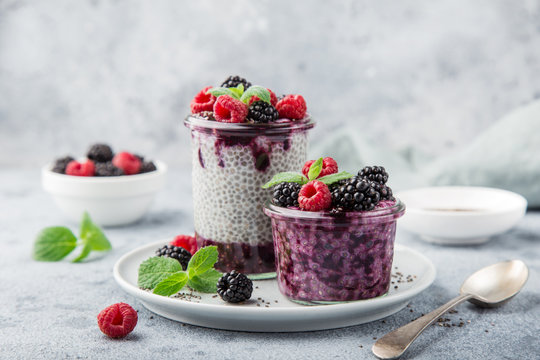 chia seeds pudding with berry sauce and fresh raspberry and blackberry in glass
