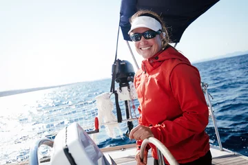 Schilderijen op glas Attractive strong woman sailing with her boat © NDABCREATIVITY