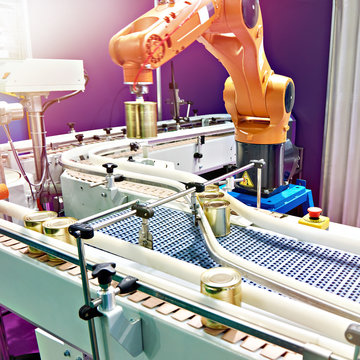 Robotic arm and cans on conveyor