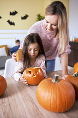 Girl carving pumpkin for Halloween