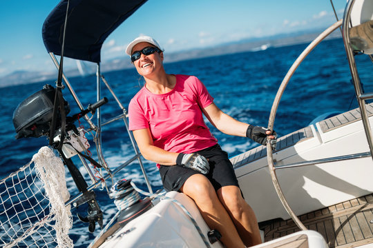 Happy strong woman sailing with her boat