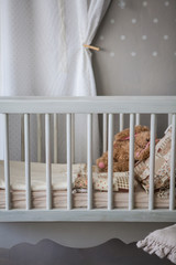 Fototapeta na wymiar Cosy baby room with baby cot and soft toys