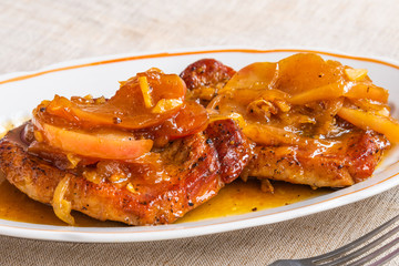 American food - pork chops in apple sauce with honey on a plate