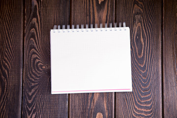 notebook on a wood background. Layout for inserting text and image