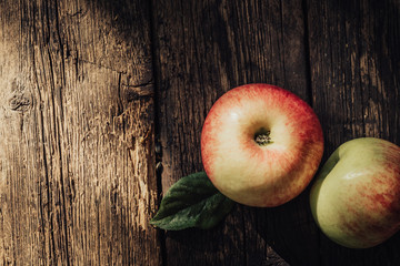 Ripe apples on rustic aged wooden background.