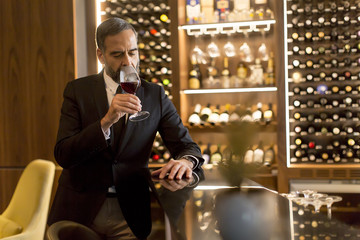 Senior handsome man drinking red wine