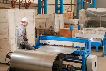 manufacture workshop. Workers adjusts the machine in the warehouse. the production of ventilation and gutters. Tool and bending equipment for sheet metal.