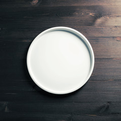 Blank white plate on wood table background. Flat lay.