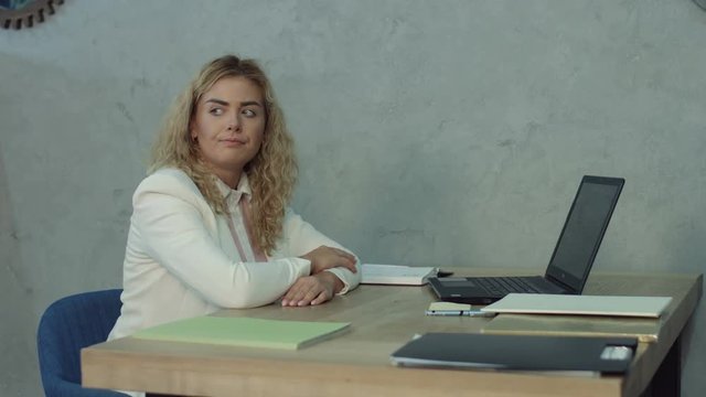 Sleepy tired female employee taking a nap at office desk, covering head with documents during business hours. Lazy unproductive worker sleeping at workplace and leaning on office desk, avoiding job.