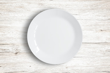 Top view of empty white food dish on a wooden background.