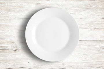Top view of empty white food dish on a wooden background.