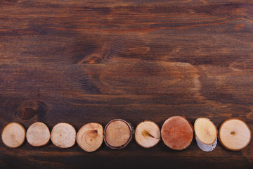 Saws of the branches of a tree on a dark brown wooden background.