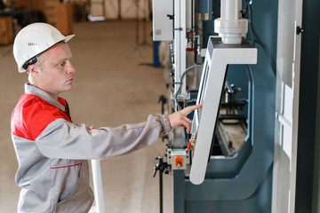 control computer display of Machine. Manufacture workers adjusts the machine in the warehouse. the production of ventilation and gutters. Tool and bending equipment for sheet metal.