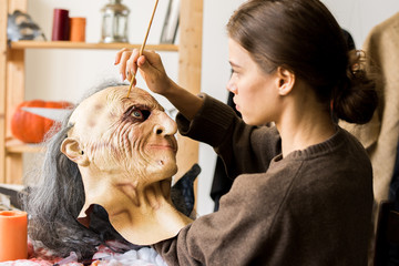 Serious woman concentrated on mask-making