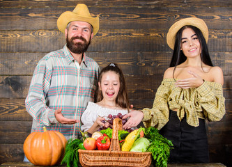 Family rustic style farmers market with fall harvest. Parents and daughter celebrate harvest holiday pumpkin vegetables basket. Harvest festival concept. Family farmers with harvest wooden background