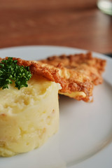 a plate with mashed potatoes and a toasted egg with tomatoes and a fork.