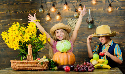 Fototapeta premium Children play vegetables pumpkin cabbage. Kids girl boy wear hat celebrate harvest festival rustic style. Celebrate fall traditions. Elementary school fall festival idea. Autumn harvest festival