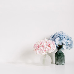 Pink and blue pastel hydrangea flower bouquets on white background. Minimal interior design concept.