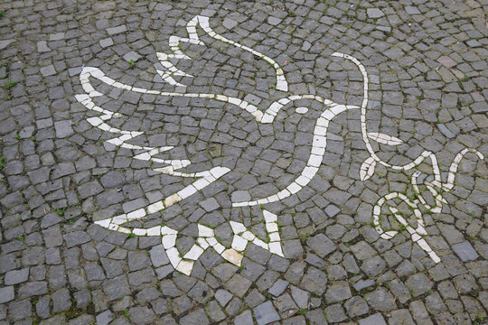 white ,brown and yellow stone put together to bird and white 'Pez mean Peace ' in English creative sidewalk in Terceira,Portugal,