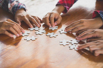 Hands of diverse people assembling jigsaw puzzle, Youth team put pieces together searching for right match, help support in teamwork to find common solution concept, top close up view
