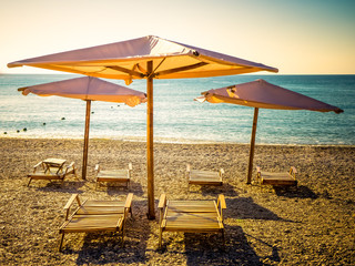 Sun umbrellas and beach beds on the sea coast