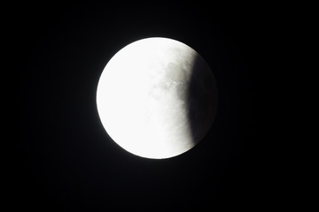 Super Bloody Moon, full eclipse last phase against black sky background, quarter of the Moon surface covered by Earth's shadow