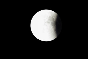 Super Bloody Moon, full eclipse last phase against black sky background, quarter of the Moon surface covered by Earth's shadow