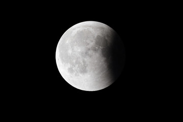 Super Bloody Moon, full eclipse last phase against black sky background, quarter of the Moon surface covered by Earth's shadow