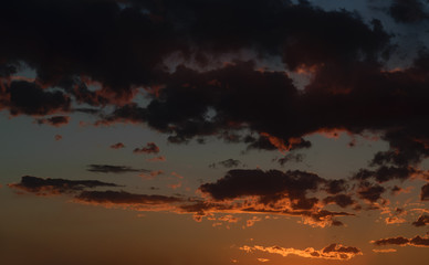 Dramatic sunset sky with orange colored clouds.