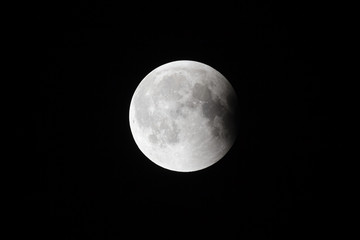 Super Bloody Moon, full eclipse last phase against black sky background, small part of Moon surface covered by Earth's shadow