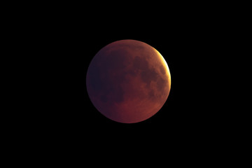 Super Bloody Moon, first phase of full eclipse against black sky background