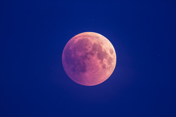 Super Bloody Moon, beginning of full eclipse phase against blue starry sky background