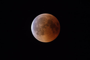 Super Bloody Moon, beginning of full eclipse end phase against starry sky background
