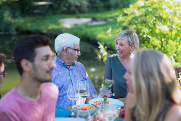 Summertime, cheerful family gathered for picnic in the garden