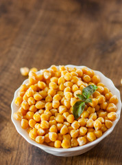 closeup of a bowl with boiled chickpeas on wooden table background