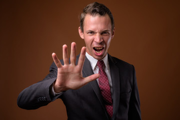 Studio shot of businessman against brown background