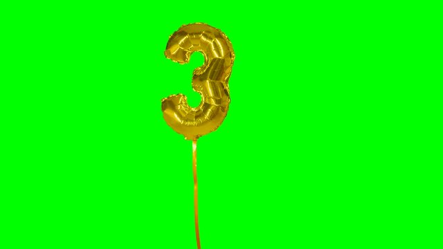 Number 3 three years birthday anniversary golden balloon floating on green screen