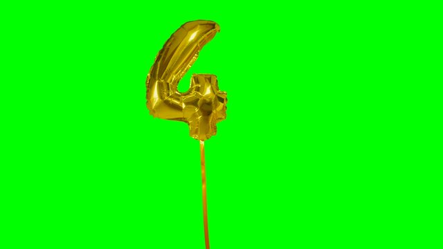 Number 4 four years birthday anniversary golden balloon floating on green screen