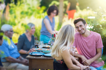 Summertime, cheerful family gathered for picnic in the garden