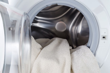 white clothes wash, open washing machine with towel closeup