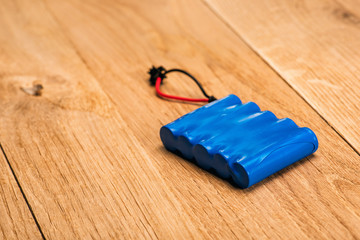 blue Battery pack isolated on wooden background
