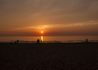Naklejka na ściany i meble people on the beach at sunset.