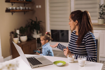 Mother working on laptop in her home