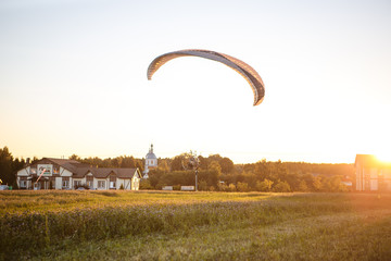 Paratrayke flight, paraglider in the sky at sunset. The wing of a parachute with a paraglider cabin...